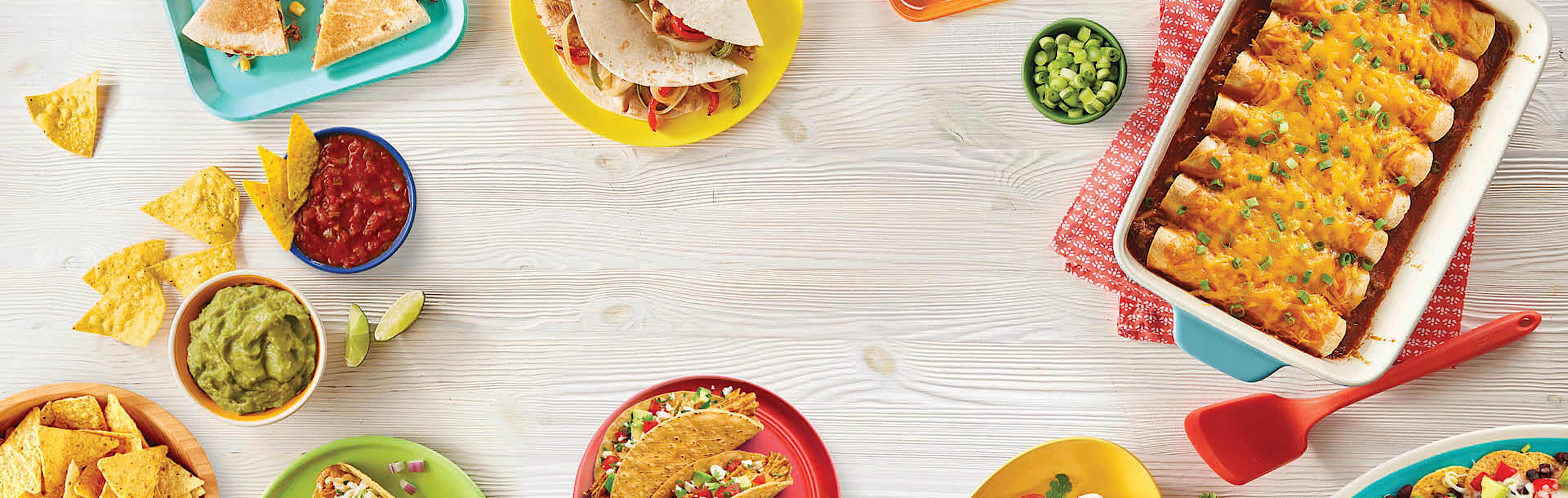 deliziosi piatti messicani come tacos, nachos, enchiladas, fajitas, burritos serviti su un tavolo di legno
